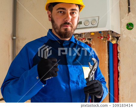 Portrait of worker or engineer in blue work clothes and yellow safety helmet Portrait of worker or engineer in blue work clothes and yellow safety helmet 109183414
