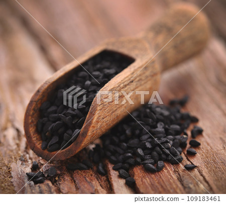 Nigella seeds in wooden scoop Nigella seeds in wooden scoop 109183461