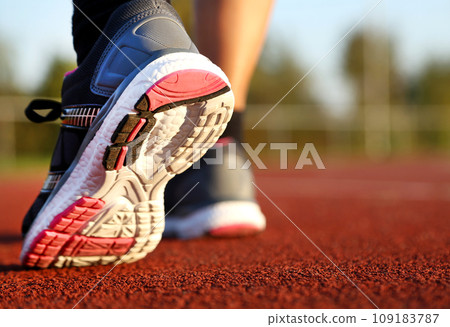 Woman running on athletic track 109183787