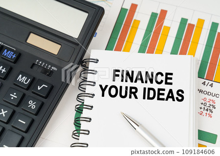 On business charts there is a calculator, a pen and a notepad with the inscription - FINANCE YOUR IDEAS On business charts there is a calculator, a pen and a notepad with the inscription - FINANCE YOUR IDEAS 109184606