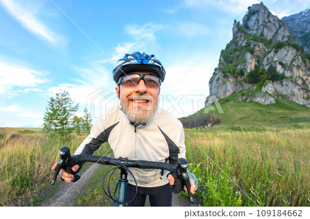 bearded man cyclist rides a bike on a road in nature. sports, hobbies and entertainment for health bearded man cyclist rides a bike on a road in nature. sports, hobbies and entertainment for health 109184662