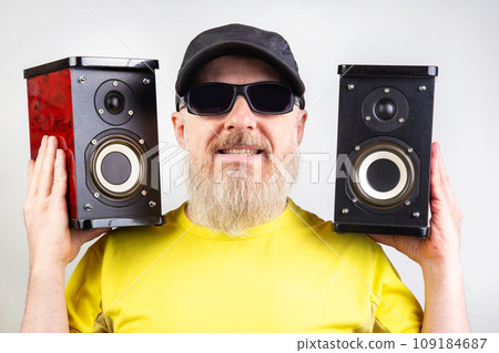 audio speakers in the hands of a bearded man. sound and modern media technologies audio speakers in the hands of a bearded man. sound and modern media technologies 109184687