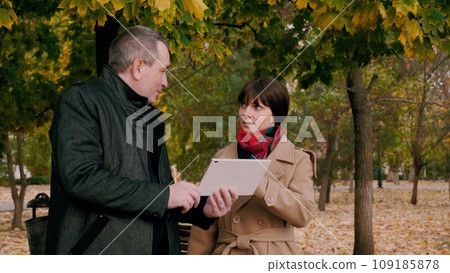 Man explains plan of action for promoting company to woman at meeting in park 109185878