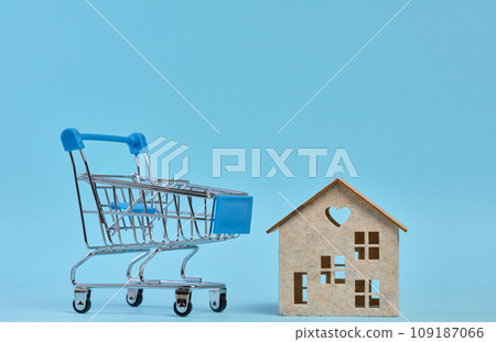 Wooden house and miniature shopping cart, representing the concept of real estate purchase, rental growth Wooden house and miniature shopping cart, representing the concept of real estate purchase, rental growth 109187066