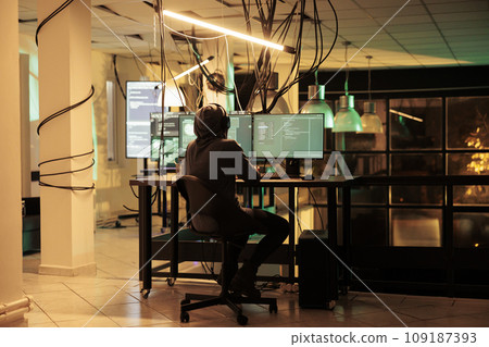 Cybercriminal planting trojan virus to cause pc malware and get access to government database, cyberattack. Hacker working on identity theft breaking into network late at night. Cybercriminal planting trojan virus to cause pc malware and get access to government database, cyberattack. Hacker working on identity theft breaking into network late at night. 109187393