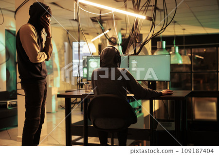 Team of thieves stealing passwords and cracking account, having access to important sensitive information on multiple monitors. Spies hacking network system, working on identity theft. 109187404