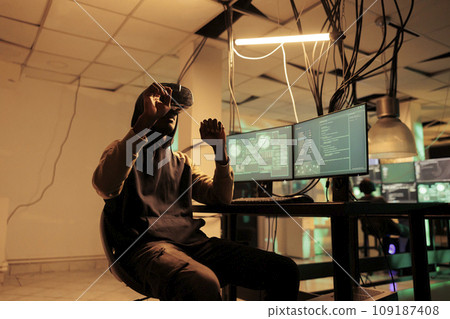 Hacker programming virus program in vr helmet, hacking computer system in metaverse, online server password cracking simulation. Cybercrime, hacker coding malware in virtual reality Hacker programming virus program in vr helmet, hacking computer system in metaverse, online server password cracking simulation. Cybercrime, hacker coding malware in virtual reality 109187408