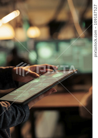 Woman analyzing computer network to hack system on tablet, using code and encrytion to break into security server. Female spy trying to hack database and steal sensitive information. 109187527