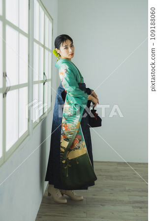 A woman wearing a furisode and hakama A woman wearing a furisode and hakama 109188060