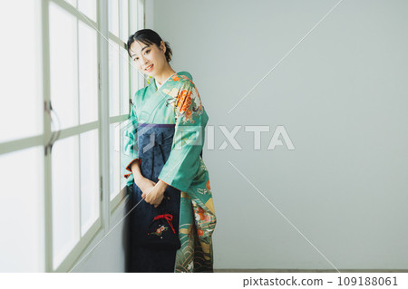 A woman wearing a furisode and hakama A woman wearing a furisode and hakama 109188061