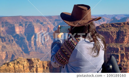 Young woman is overwhelmed by view over the Grand Canyon 109189160