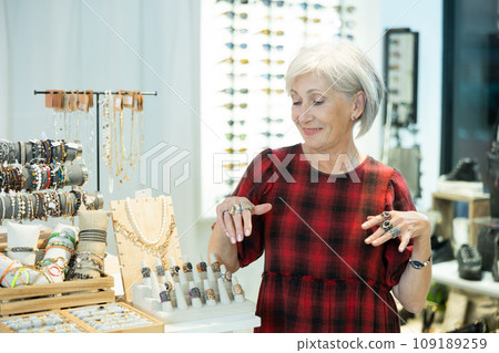 Elderly woman chooses ring in store 109189259