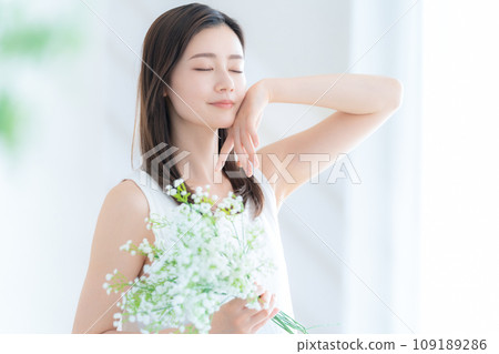 Young woman with a bouquet of hazy grass in the living room Young woman with a bouquet of hazy grass in the living room 109189286