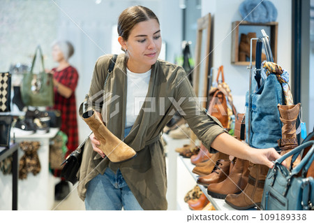 Young woman choosing ankle boots in store Young woman choosing ankle boots in store 109189338