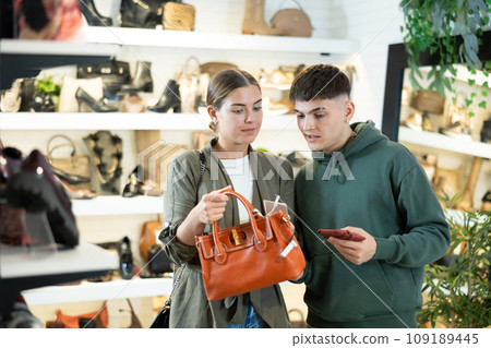 Couple man and woman choosing handbag and wallet in store Couple man and woman choosing handbag and wallet in store 109189445