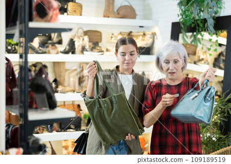 Young and elderly women choosing handbag in store Young and elderly women choosing handbag in store 109189519