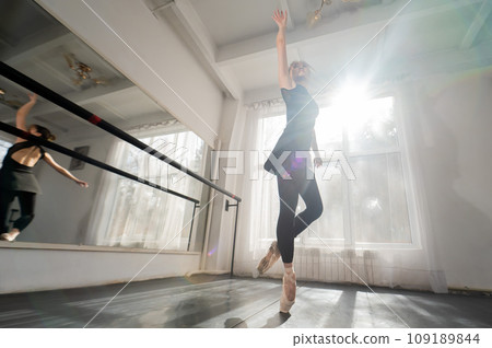 A beautiful Asian woman is dancing at the barre. Ballet dancer. 109189844
