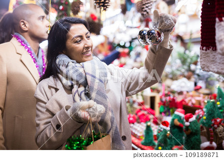Portrait of woman customer near counter with Christmas gifts in evening time 109189871