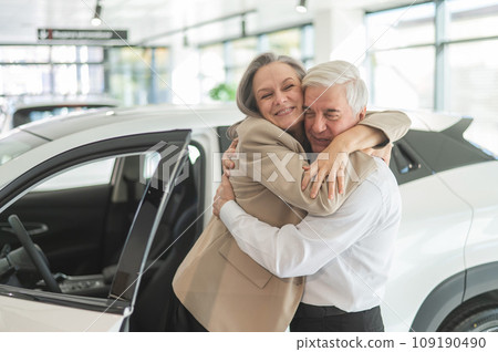 Mature Caucasian couple hugging. Elderly man and woman buying a new car.  109190490