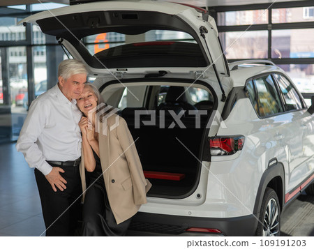 Mature Caucasian couple choosing a car looks at the trunk. Mature Caucasian couple choosing a car looks at the trunk. 109191203