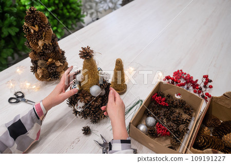 Elderly caucasian woman making cones decoration for christmas. 109191227