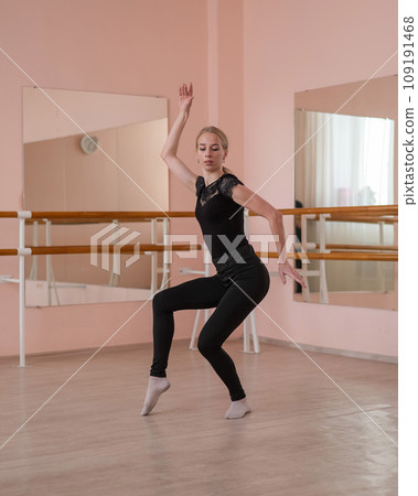 Caucasian blonde woman is practicing ballet in class. Rehearsal. Vertical photo. Caucasian blonde woman is practicing ballet in class. Rehearsal. Vertical photo. 109191468