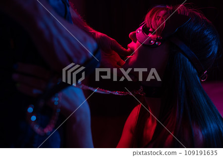 Role-playing games. Man putting finger in woman's mouth in cat mask.  109191635