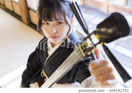 一位穿著和服的年輕女子在調三味線 109192791