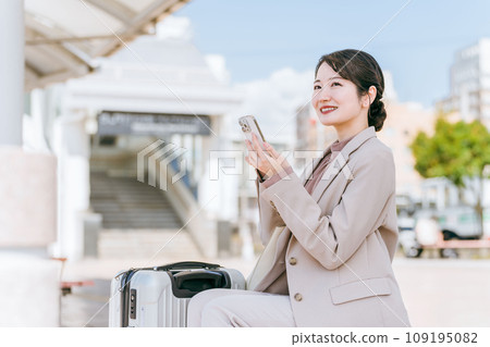 一位女士使用叫車應用程式從車站/機場叫計程車/租車(出差/租車/旅行) 一位女士使用叫車應用程式從車站/機場叫計程車/租車(出差/租車/旅行) 109195082