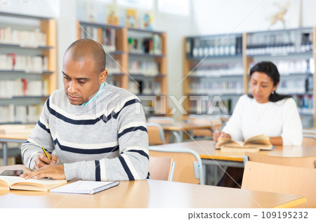 Young adult man studying in public library 109195232