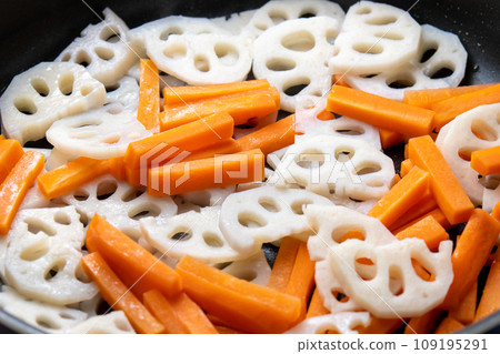 Carrot and lotus root kinpira, cooking scene. Carrot and lotus root kinpira, cooking scene. 109195291