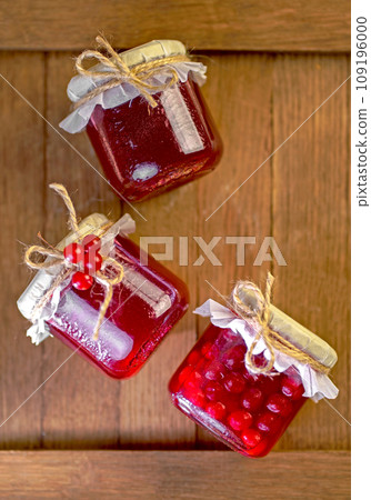 viburnum jam. Red juicy berries of a viburnum with sugar in a glass jar on a dark wooden background. For making jam, tea. Medicinal plant. viburnum jam. Red juicy berries of a viburnum with sugar in a glass jar on a dark wooden background. For making jam, tea. Medicinal plant. 109196000