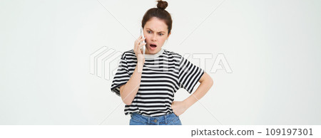 Image of brunette woman arguing, shouting on telephone, having an argument on mobile phone, standing over white background 109197301