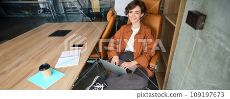 Business and lifestyle concept. Young woman in casual clothes, working on laptop, sitting in office 109197673
