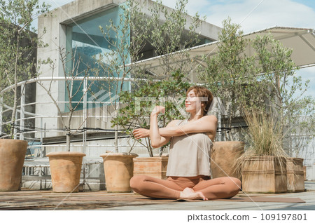 A woman doing yoga, exercise, Pilates, and stretching on the rooftop (diet/health care) A woman doing yoga, exercise, Pilates, and stretching on the rooftop (diet/health care) 109197801