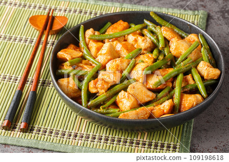 Phat phrik khing or pad prik king is a Thai stir-fried red curry with chicken and long beans closeup on the plate. Horizontal 109198618