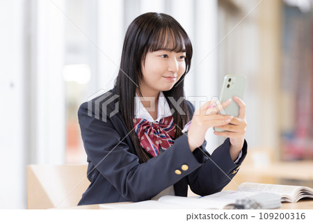 High school girl studying while looking at her smartphone Photography cooperation: Ariake College of Education and Arts High school girl studying while looking at her smartphone Photography cooperation: Ariake College of Education and Arts 109200316