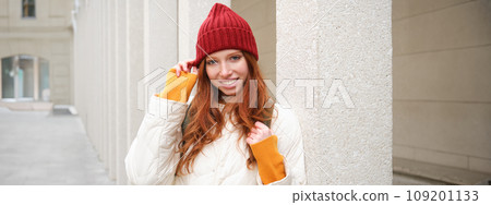 Female tourist in red hat with backpack, sightseeing, explores historical landmarks on her trip around europe, smiling and posing on street Female tourist in red hat with backpack, sightseeing, explores historical landmarks on her trip around europe, smiling and posing on street 109201133