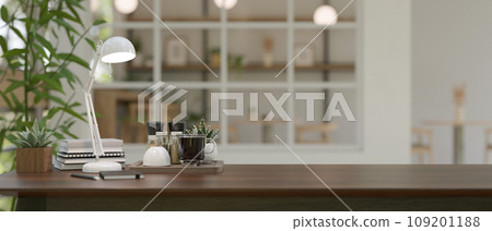 Wooden table in a study room with coffee cup on the table and blurred background living room. 109201188