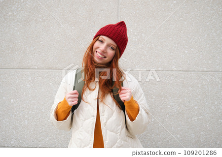 Happy young girl, redhead tourist in red hat with backpack, walks around town, explores city, backpacking around europe, travelling alone Happy young girl, redhead tourist in red hat with backpack, walks around town, explores city, backpacking around europe, travelling alone 109201286