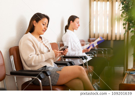 Positive woman sitting at hall at office 109201639