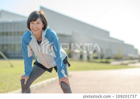 Healthy woman stretching and warming up outside 109201737
