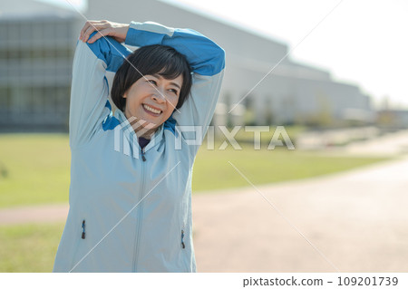 Healthy woman stretching and warming up outside 109201739