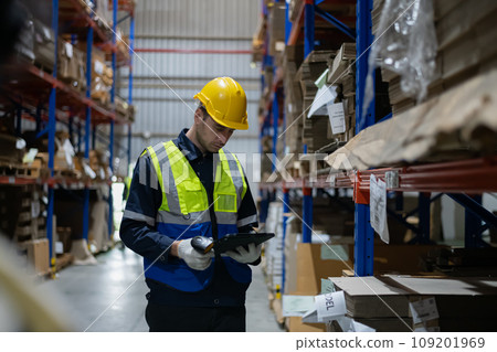 Employees check products using a tablet in the warehouse. Employees check products using a tablet in the warehouse. 109201969