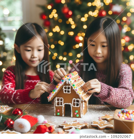 children making Gingerbread house decorated with colorful candies against Christmas tree background children making Gingerbread house decorated with colorful candies against Christmas tree background 109202067