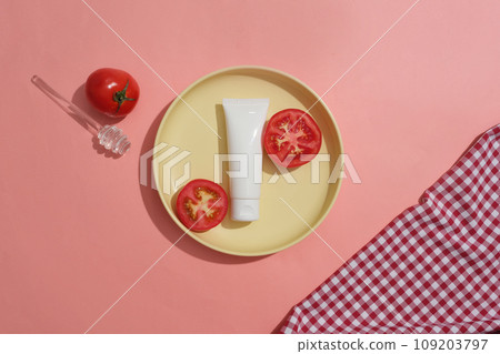 Yellow dish with an unlabeled tube and halves of tomato placed on. Branding mockup. Tomatoes are a natural and chemical-free way to reduce acne and pimples Yellow dish with an unlabeled tube and halves of tomato placed on. Branding mockup. Tomatoes are a natural and chemical-free way to reduce acne and pimples 109203797