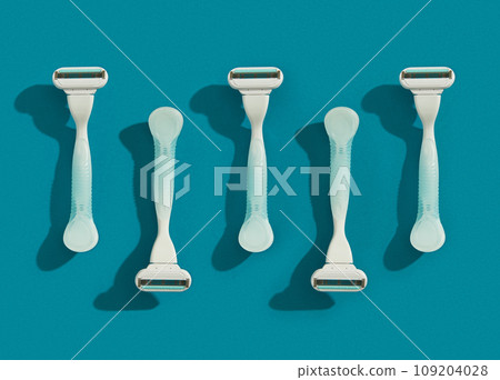 Minimalist elegance: Razor in sharp relief against a bold blue canvas with dramatic shadows Minimalist elegance: Razor in sharp relief against a bold blue canvas with dramatic shadows 109204028