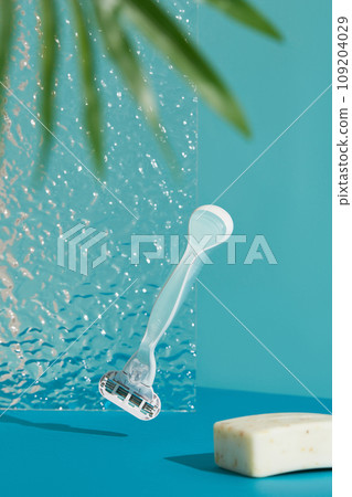 Minimalist elegance: Razor in sharp relief against a bold blue backdrop with dramatic shadows Minimalist elegance: Razor in sharp relief against a bold blue backdrop with dramatic shadows 109204029