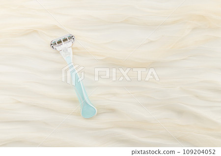 Razor on soft fabric. Tactile elegance, transforming your grooming routine into a silky experience 109204052