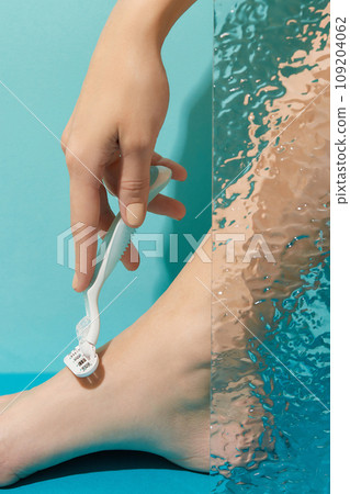 Precision in hand: A razor held against a striking blue backdrop, capturing the essence of grooming finesse 109204062